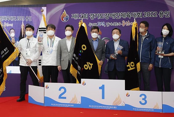 종합 1위를 한 수원시와, 2위 성남시, 3위 부천시 관계자가 시상대에서 기념촬영을 하고 있다-